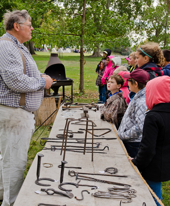 Blacksmith teaching school kids